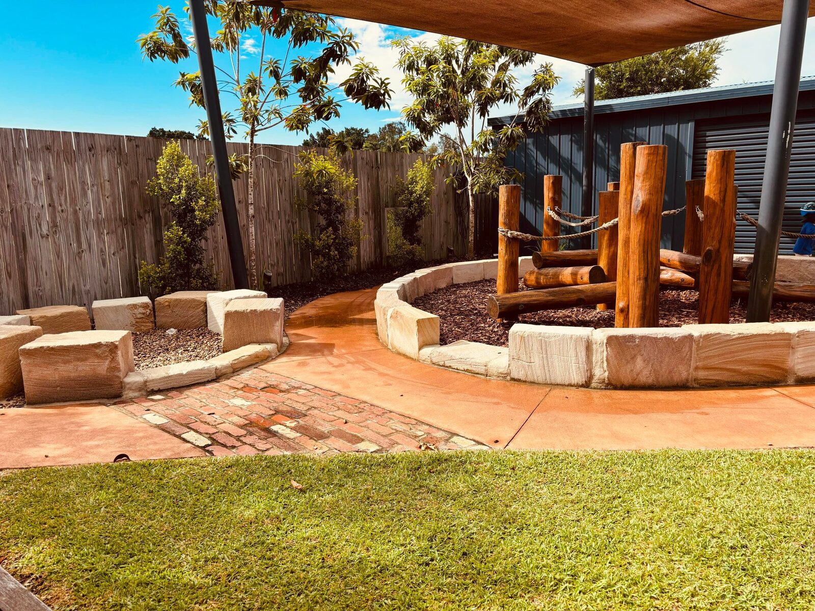 Outdoor amphitheatre with timber seating around a central fire pit