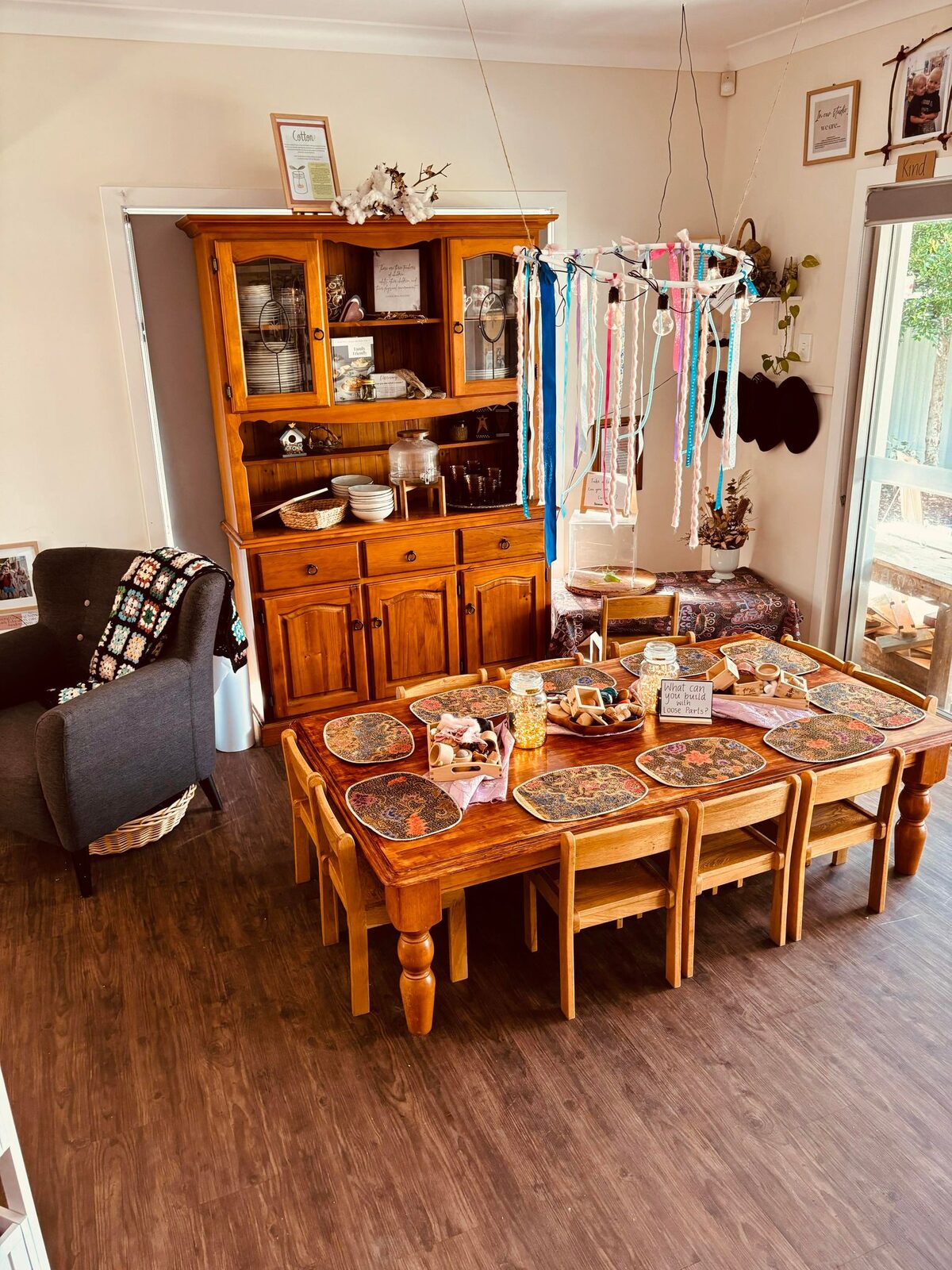 Indoor dining and dramatic play room with timber furniture and natural light